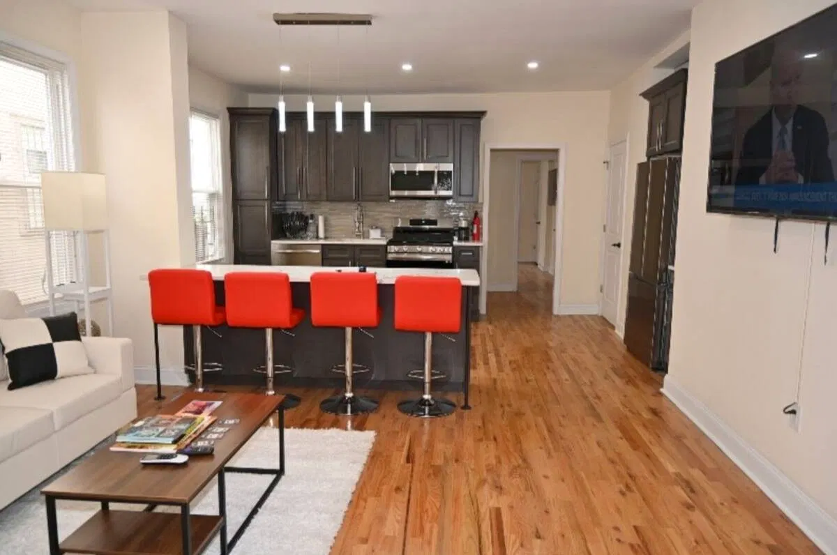 OoohLaLa furnished living room, white sectional and red kitchen seating