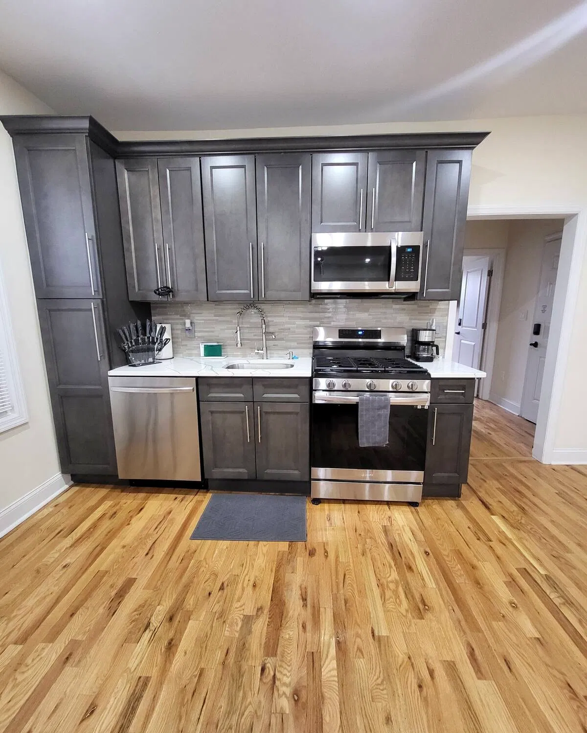 OoohLaLa@Newark — Dark cabinetry, stainless-steel appliances and practical kitchen storage for everyday meals.